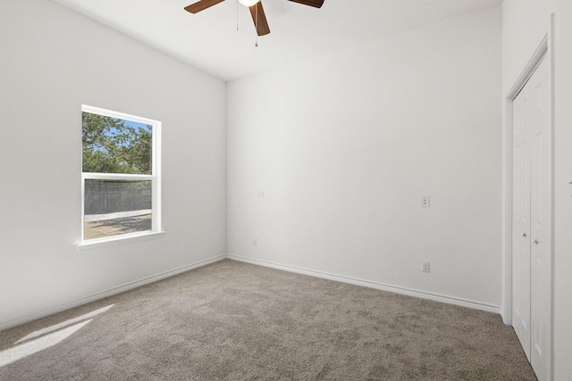 spare room featuring a ceiling fan, carpet flooring, and baseboards