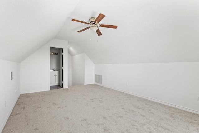 additional living space with visible vents, vaulted ceiling, carpet floors, and baseboards