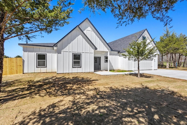 modern inspired farmhouse featuring fence, roof with shingles, board and batten siding, and concrete driveway