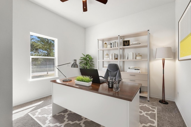 office featuring light colored carpet, a ceiling fan, and baseboards