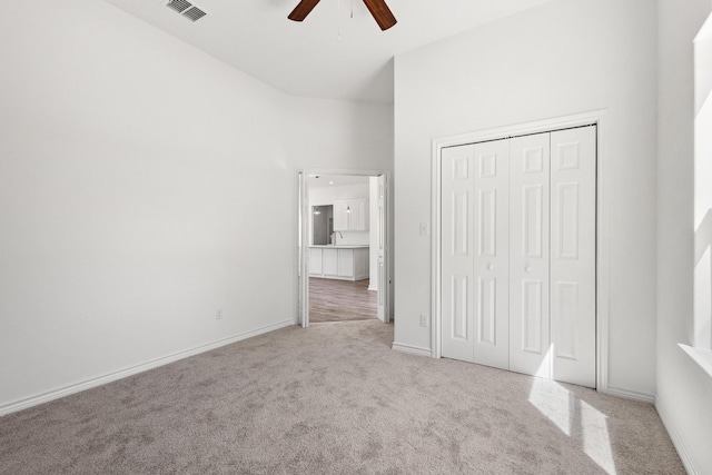 unfurnished bedroom with carpet flooring, visible vents, ceiling fan, baseboards, and a closet