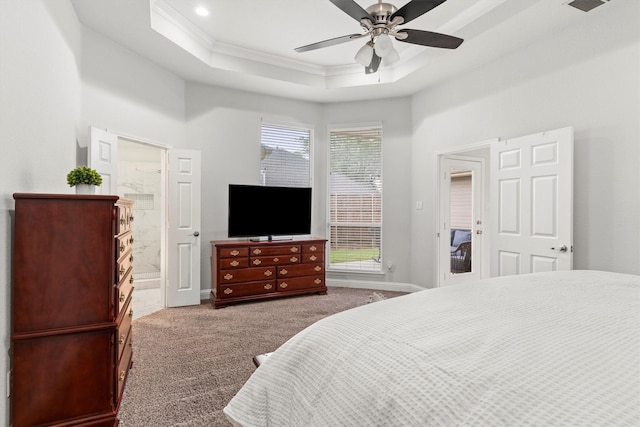 bedroom featuring carpet floors, crown molding, a tray ceiling, a ceiling fan, and ensuite bath