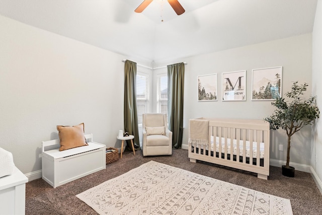 bedroom featuring ceiling fan, a crib, baseboards, and carpet