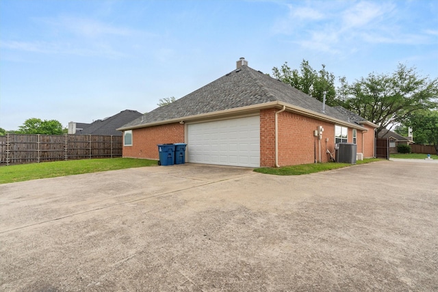 view of side of property with brick siding, a garage, fence, and driveway