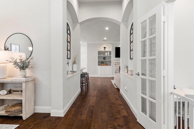 hall featuring recessed lighting, arched walkways, built in features, and wood finished floors