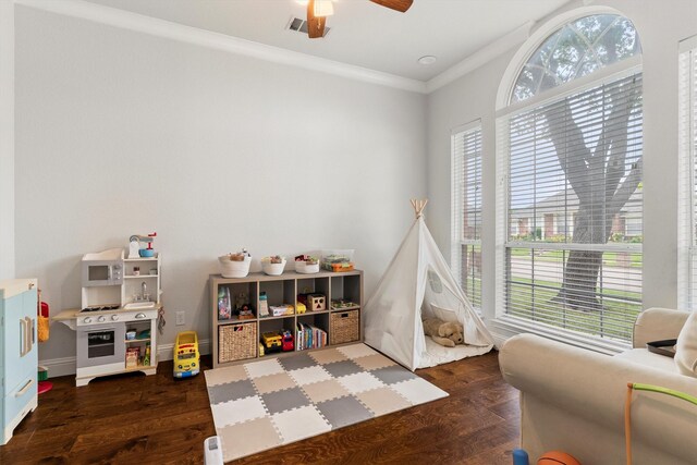 recreation room featuring crown molding, a ceiling fan, wood finished floors, and visible vents