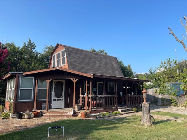 view of front of property featuring a gambrel roof, a porch, a shingled roof, and a front yard