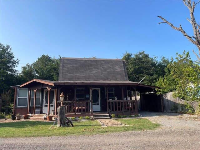 view of front of house with driveway, fence, covered porch, and roof with shingles