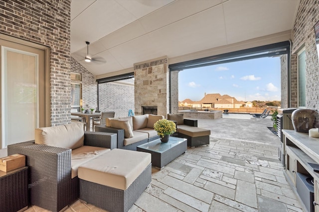 view of patio / terrace featuring ceiling fan and an outdoor living space with a fireplace