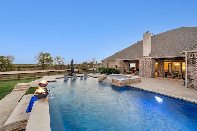 view of pool featuring fence, a fire pit, a patio area, and a pool with connected hot tub