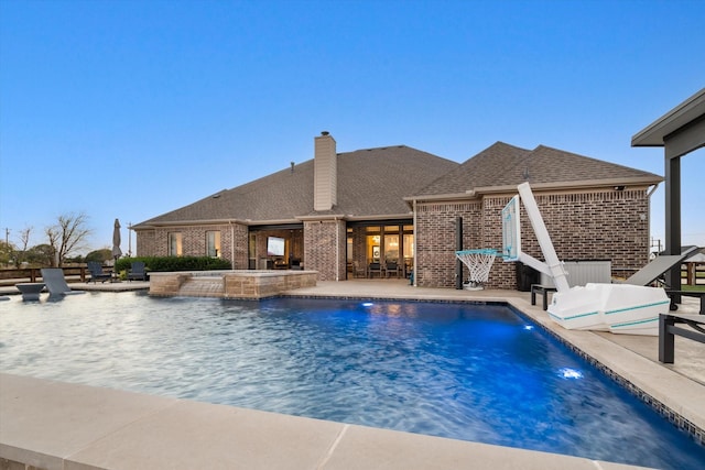 view of swimming pool featuring a pool with connected hot tub and a patio area