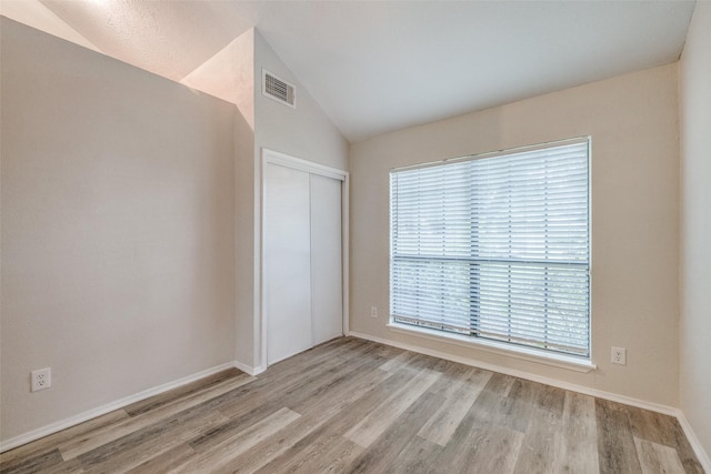 2406 Sutton Dr, Arlington, TX 76018 - spare room with baseboards, wood finished floors, a healthy amount of sunlight, and vaulted ceiling
