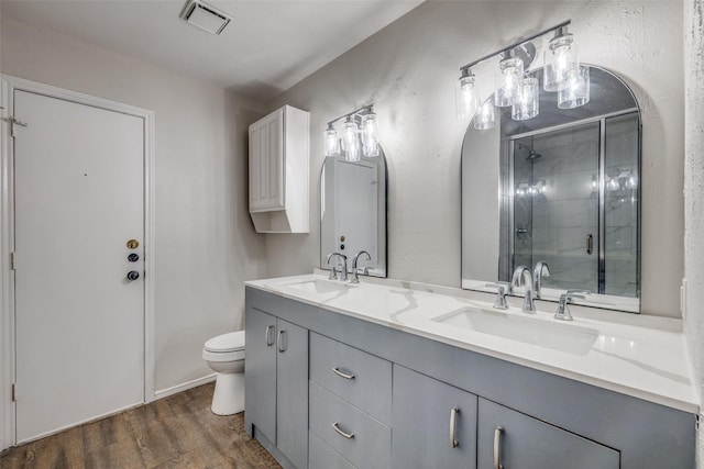 2406 Sutton Dr, Arlington, TX 76018 - bathroom featuring visible vents, a shower stall, a sink, and wood finished floors