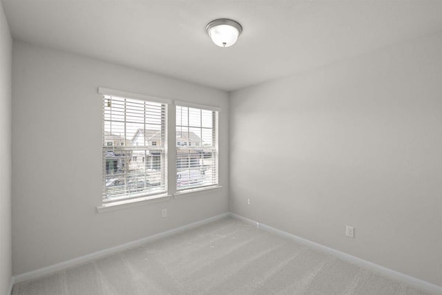 carpeted empty room with baseboards