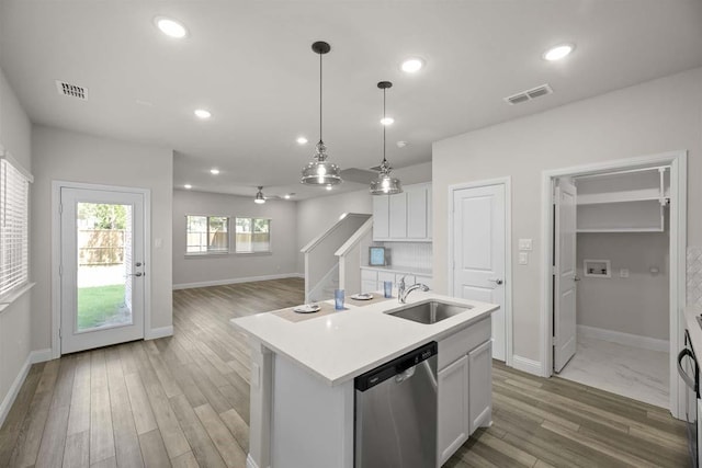 kitchen featuring light countertops, dishwasher, a sink, and visible vents