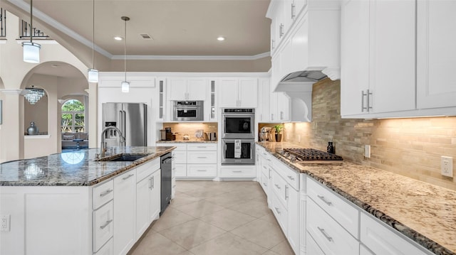 kitchen featuring a sink, visible vents, ornamental molding, arched walkways, and appliances with stainless steel finishes