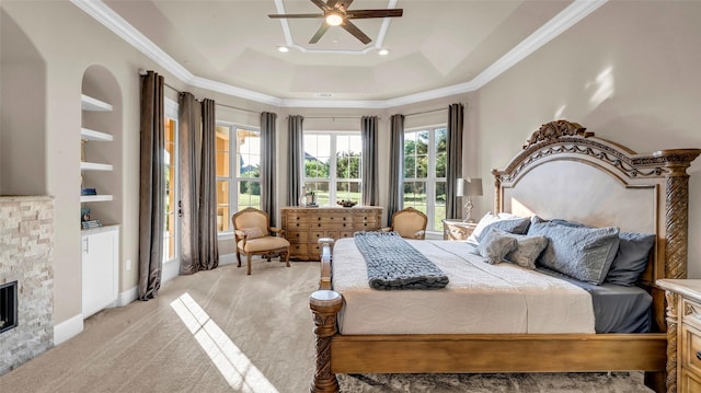 bedroom featuring crown molding, light colored carpet, a raised ceiling, a fireplace, and a ceiling fan