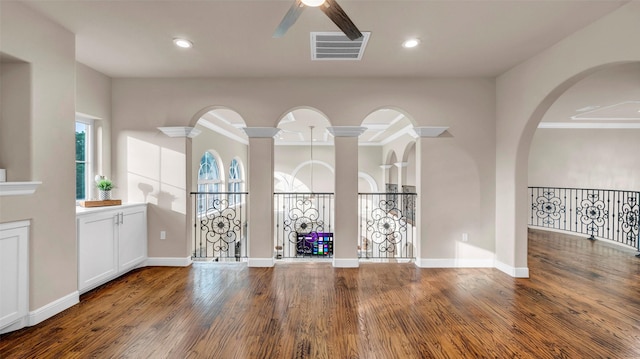 interior space with baseboards, visible vents, wood finished floors, and a ceiling fan