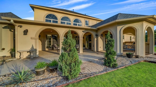 back of house with stucco siding and a patio