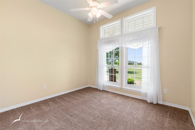 carpeted empty room with baseboards and a ceiling fan