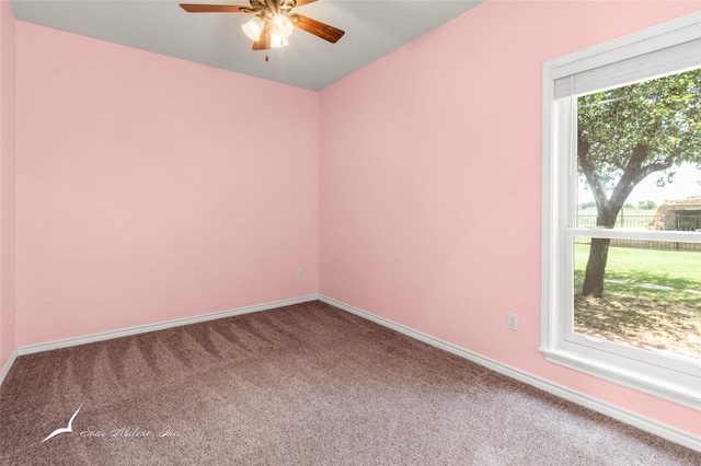 carpeted empty room featuring a ceiling fan and baseboards