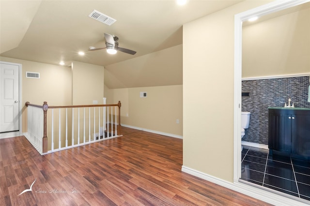 additional living space with a ceiling fan, visible vents, wood finished floors, and lofted ceiling