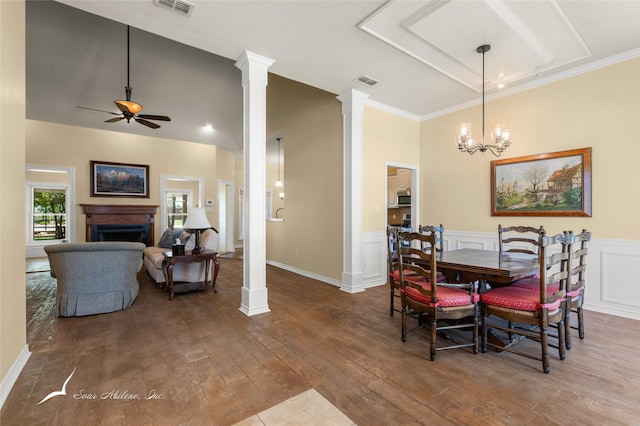 dining area with visible vents, decorative columns, hardwood / wood-style flooring, and ceiling fan with notable chandelier