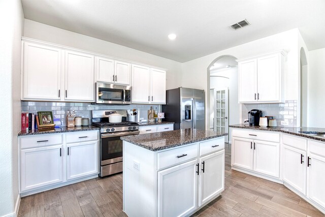 300 Copper Switch Dr, Anna, TX 75409 - kitchen featuring appliances with stainless steel finishes, light wood-style floors, and arched walkways
