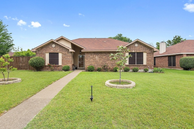 single story home featuring a front lawn, fence, and brick siding