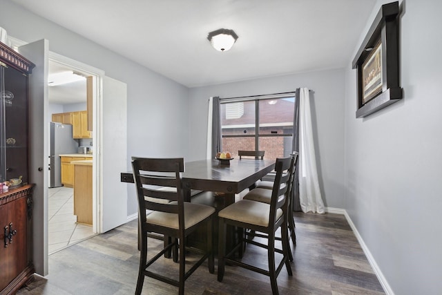 dining area featuring baseboards and light wood-type flooring