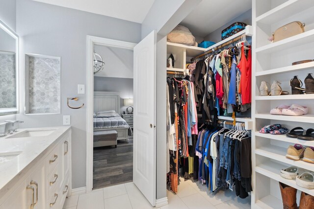 walk in closet featuring light tile patterned floors and a sink