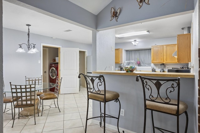 kitchen featuring an inviting chandelier, light tile patterned floors, visible vents, pendant lighting, and a kitchen breakfast bar
