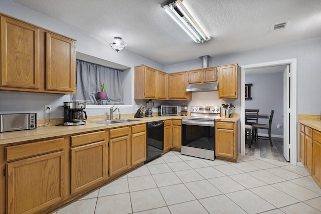 kitchen with under cabinet range hood, appliances with stainless steel finishes, light countertops, a sink, and visible vents