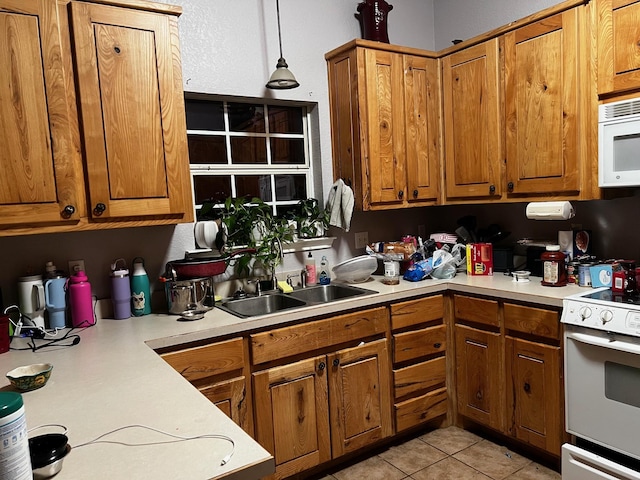 kitchen with a sink, light countertops, brown cabinets, and white appliances