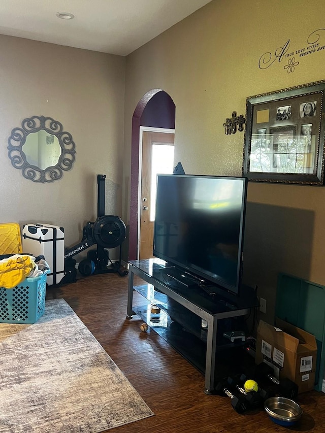 living room with arched walkways and dark wood-type flooring