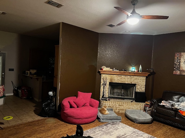 living room with visible vents, a ceiling fan, tile patterned floors, and a fireplace