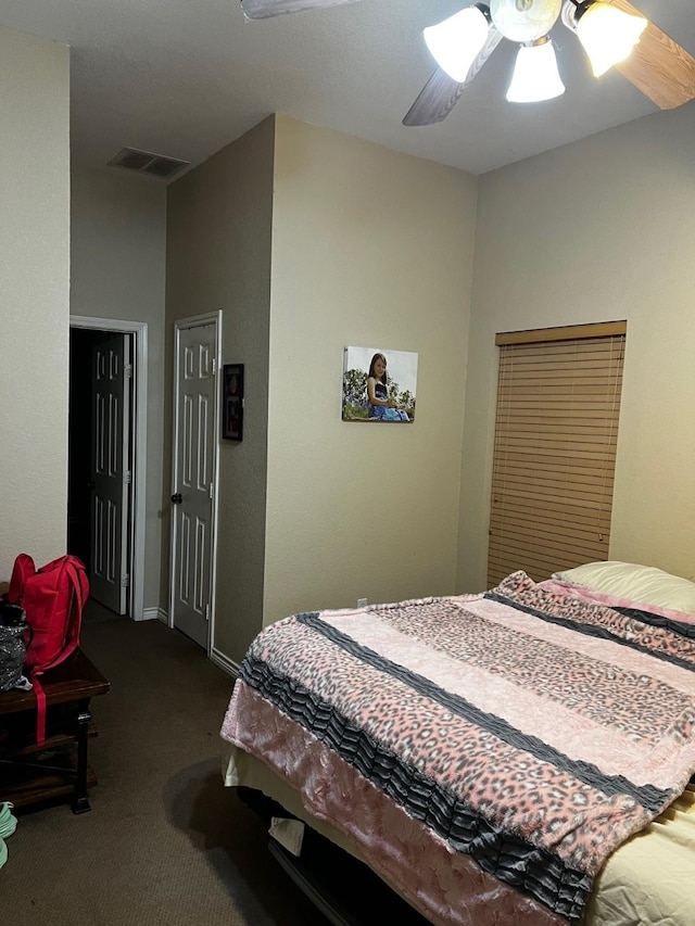bedroom with dark carpet, a ceiling fan, baseboards, and visible vents