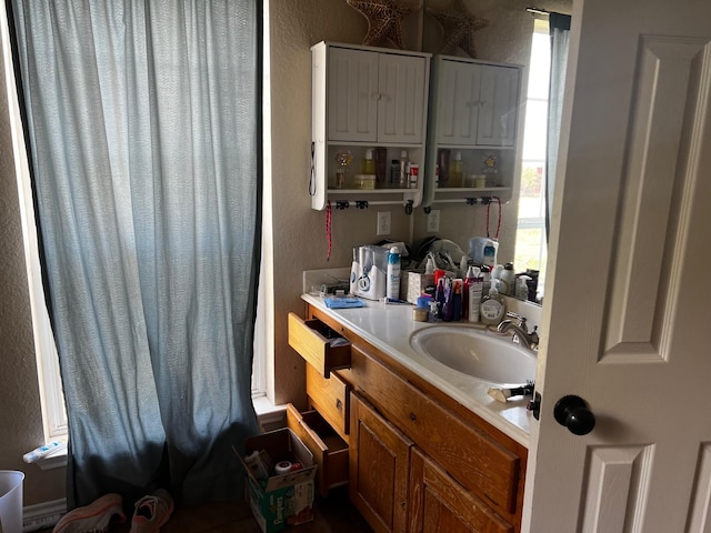 bathroom with a textured wall and vanity