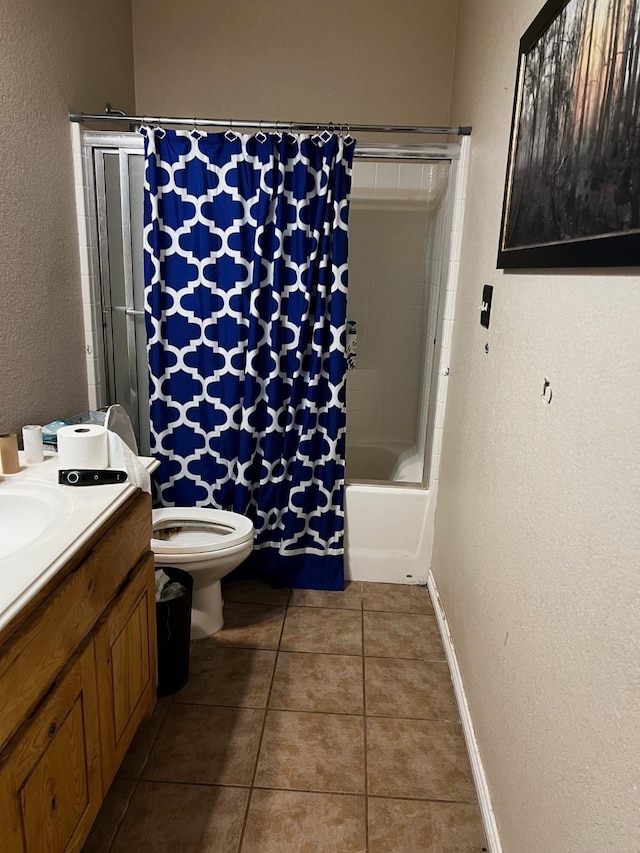 bathroom featuring toilet, a textured wall, tile patterned flooring, and vanity
