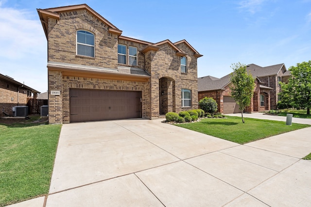 view of front facade with a front yard, driveway, central AC unit, and brick siding