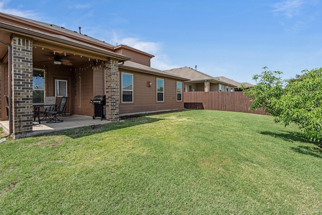 view of yard featuring fence, a ceiling fan, and a patio area