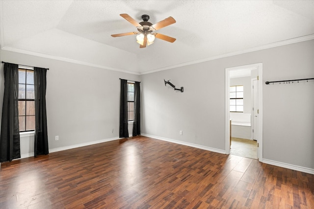 empty room with ornamental molding, ceiling fan, wood finished floors, and a healthy amount of sunlight