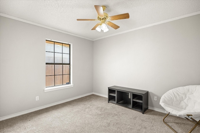 sitting room with carpet, ornamental molding, baseboards, a ceiling fan, and a textured ceiling