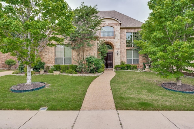 751 Chateaus Dr, Coppell, TX 75019 - french country inspired facade with a balcony, a shingled roof, a front yard, and brick siding