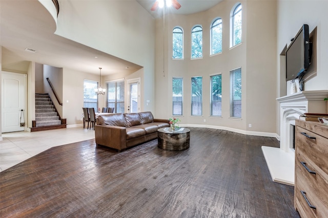 751 Chateaus Dr, Coppell, TX 75019 - living area featuring stairs, a fireplace with raised hearth, baseboards, and ceiling fan with notable chandelier