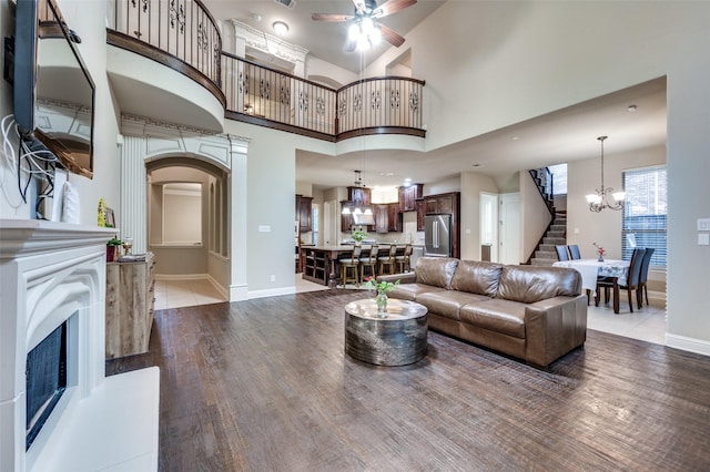751 Chateaus Dr, Coppell, TX 75019 - living room with stairs, a fireplace with raised hearth, baseboards, and ceiling fan with notable chandelier