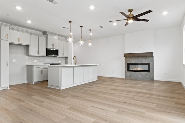 723 Tower Rd, Wylie, TX 75098 - kitchen featuring stainless steel microwave, a sink, ceiling fan, light countertops, and light wood-style floors