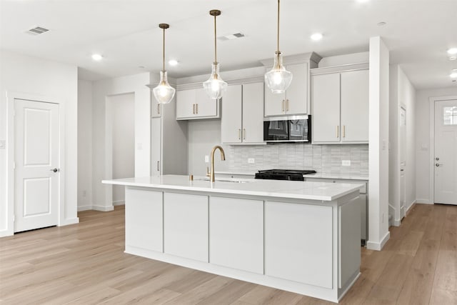 723 Tower Rd, Wylie, TX 75098 - kitchen with a sink, stainless steel microwave, stove, backsplash, and baseboards