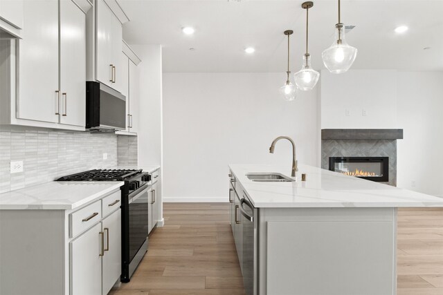 723 Tower Rd, Wylie, TX 75098 - kitchen with appliances with stainless steel finishes, a sink, light wood-style flooring, a center island with sink, and recessed lighting