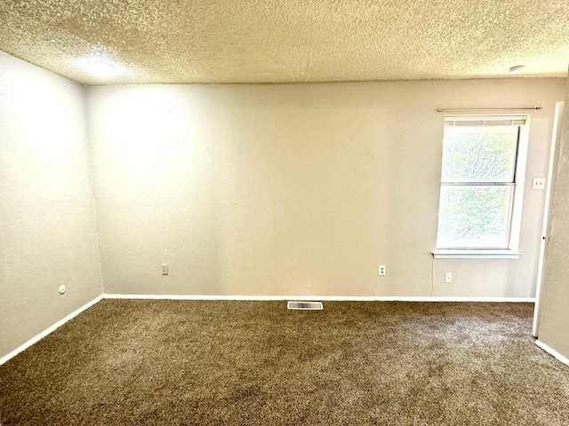 carpeted spare room featuring a textured ceiling, visible vents, and baseboards